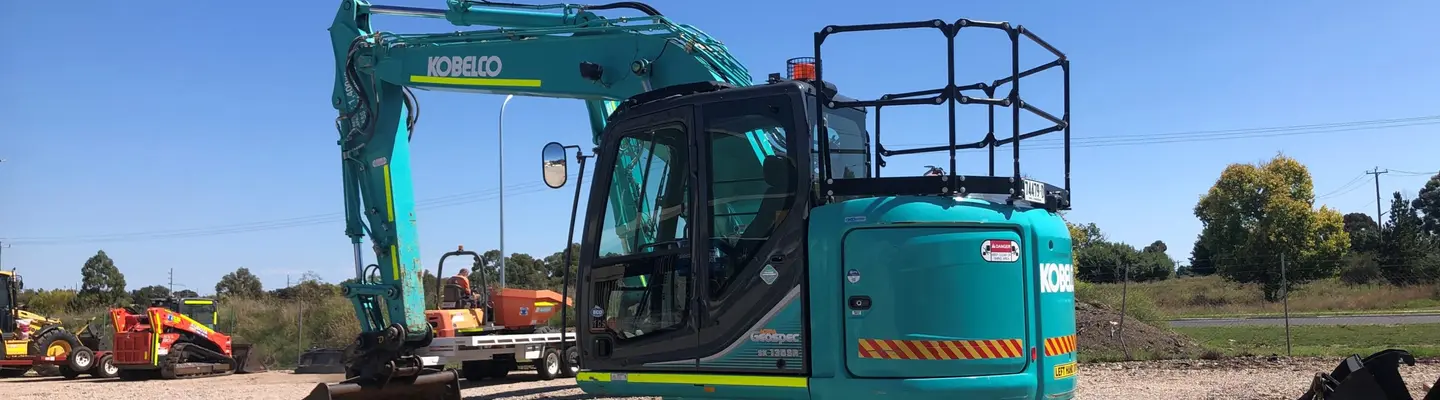 Construction equipment positioned at a roadside site, used for installing or maintaining safety barriers.
