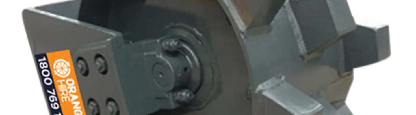 Compaction wheel attachment on an excavator, used to compress soil on a construction site with safety barriers nearby.