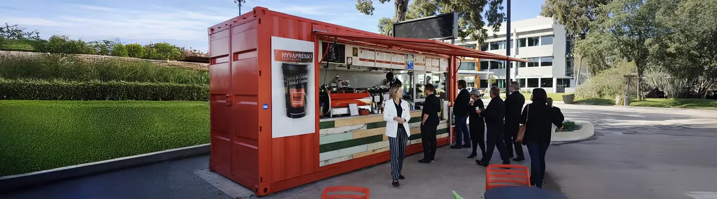  Custom-modified shipping container converted into a Koffee Kiosk with serving window and outdoor seating area.