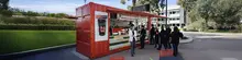  Custom-modified shipping container converted into a Koffee Kiosk with serving window and outdoor seating area.